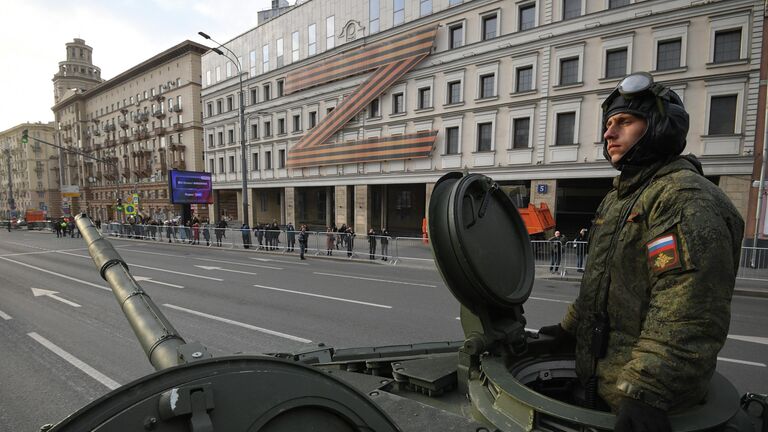 Военнослужащий в колонне военной техники двигается по улице в Москве к месту проведения ночной репетиции военного парада к 77-й годовщине Победы в Великой Отечественной войне