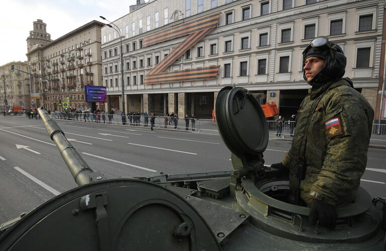 Военнослужащий в колонне военной техники двигается по улице в Москве к месту проведения ночной репетиции военного парада к 77-й годовщине Победы в Великой Отечественной войне