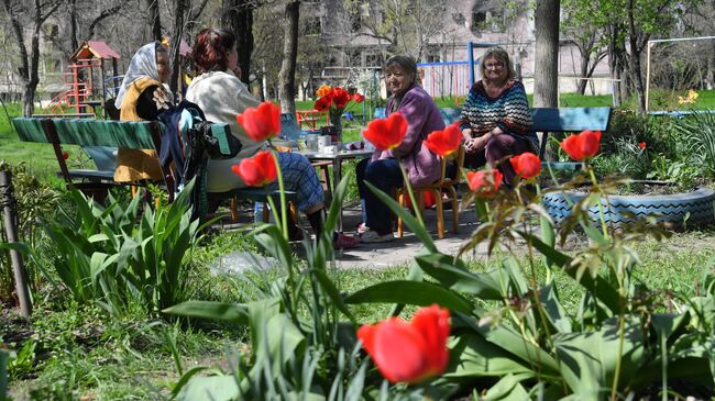 Жители во дворе своего разрушенного дома в Мариуполе