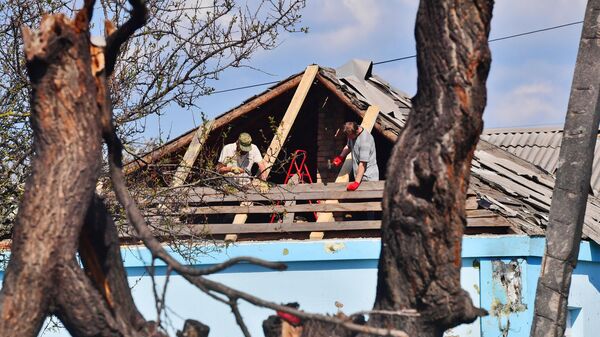 Жители Мариуполя вернулись к своему разрушенному дому в Левобережном районе. Отец и сын чинят крышу