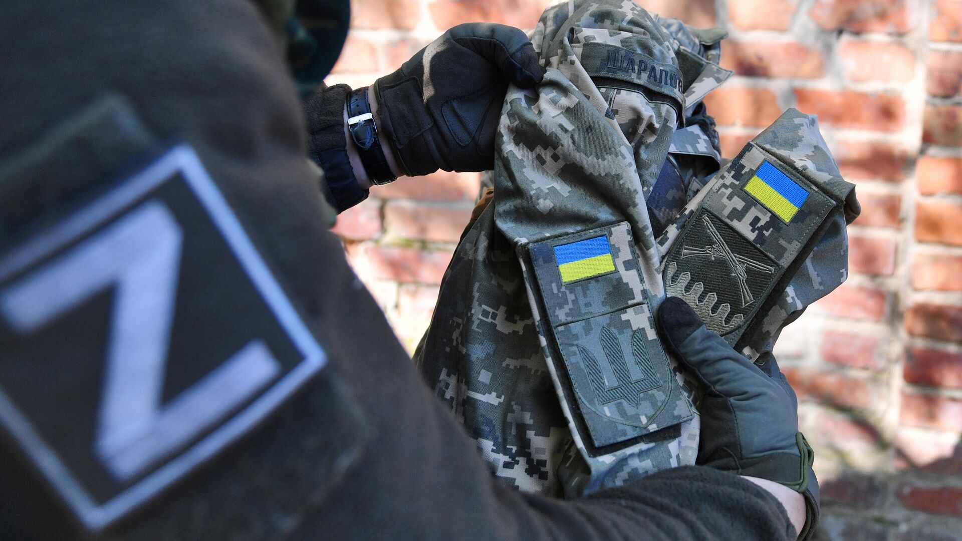 Боец МВД ЛНР демонстрирует найденную форму украинского военнослужащего - РИА Новости, 1920, 22.05.2022