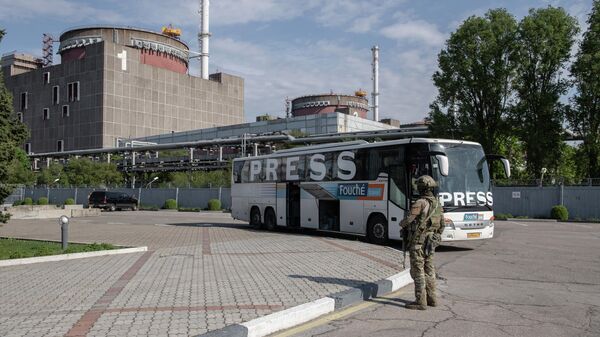 Военнослужащий ВС РФ и автобус с международной прессой на территории Запорожской АЭС в Энергодаре