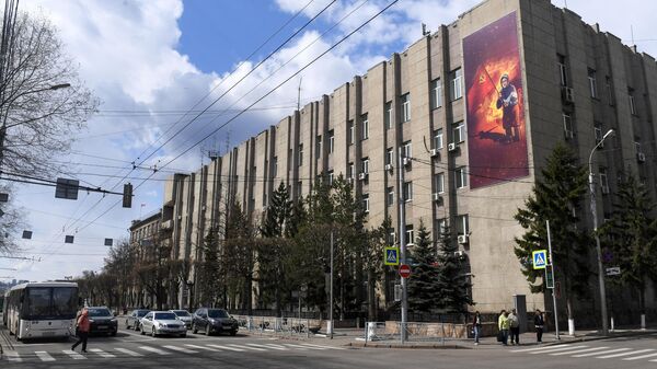 Баннер с изображением бабушки с красным флагом на стене здания ГУ МВД России по Красноярскому краю