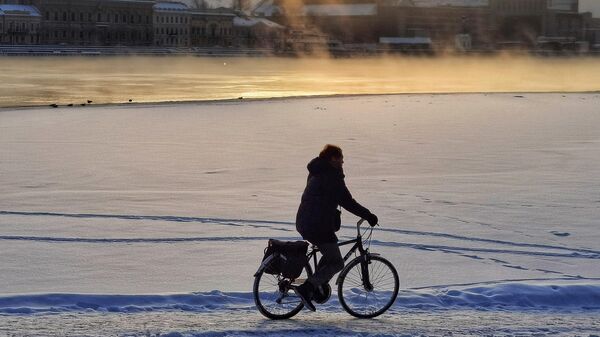 Велосипедист едет по набережной Невы в Санкт-Петербурге