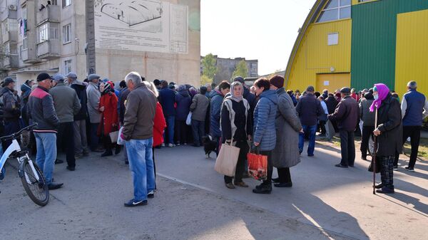 Люди стоят в очереди у пункта выдачи гуманитарной помощи из России жителям Волчанска Харьковской области
