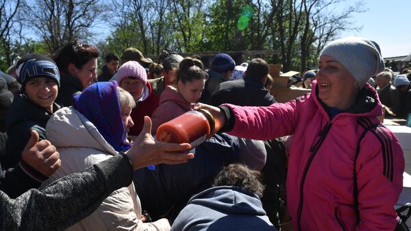 Местные жители стоят в очереди за российской гуманитарной помощью в одном из сел в Харьковской области