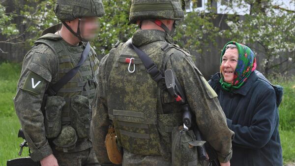 Военнослужащие ВС РФ общаются с пожилой жительницей одного из сел в Харьковской области