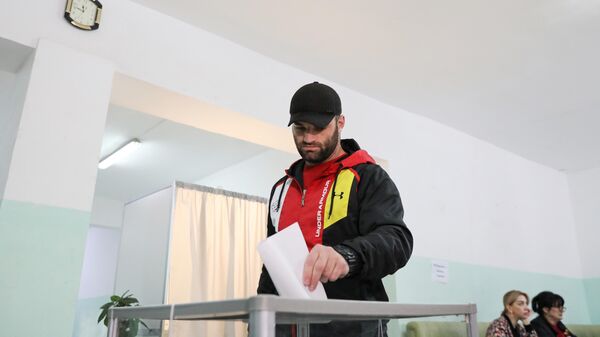 Мужчина голосует на избирательном участке в Цхинвале