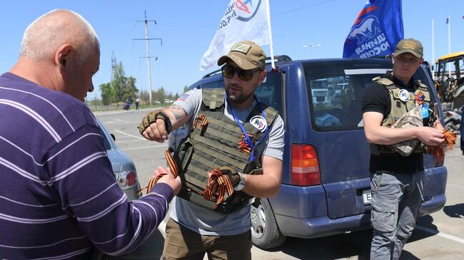 Волонтеры раздают Георгиевские ленты во время подготовки к празднованию 9 мая в ДНР