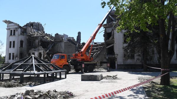 Разбор завалов на месте разрушенного Донецкого академического областного драматического театра в Мариуполе