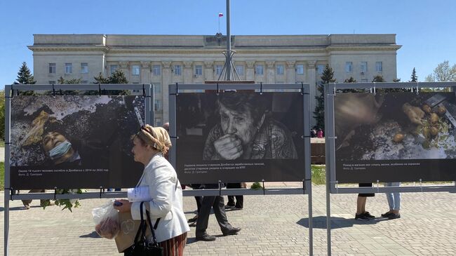 Женщина на площади Свободы в Херсоне, где размещена фотовыставка о преступлениях ВСУ в Донбассе