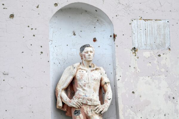 Поврежденная от обстрелов статуя на железнодорожном вокзале города Попасная