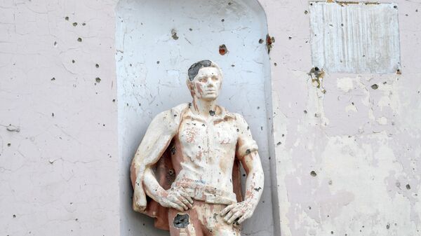 Поврежденная от обстрелов статуя на железнодорожном вокзале города Попасная