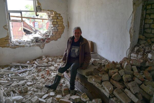 Мужчина в своем разрушенном доме в городе Попасная