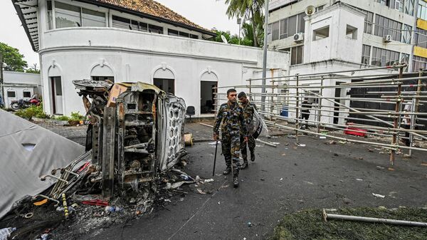 Автомобиль, сгоревший в результате беспорядков, возле резиденции бывшего премьер-министра Шри-Ланки в Коломбо