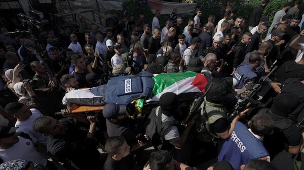 Вооруженные люди несут тело журналистки Al Jazeera на Западном берегу реки Иордан