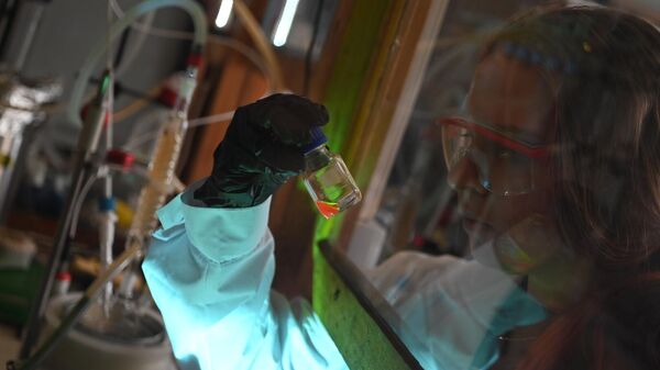 Научный сотрудник, держащий в руке образец флуоресцентных квантовых точек