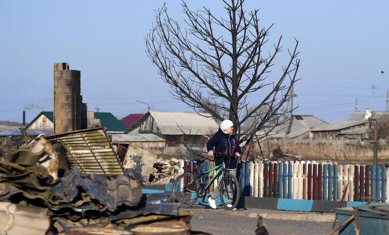 Женщина возле сгоревшего дома в городе Уяре Красноярского края