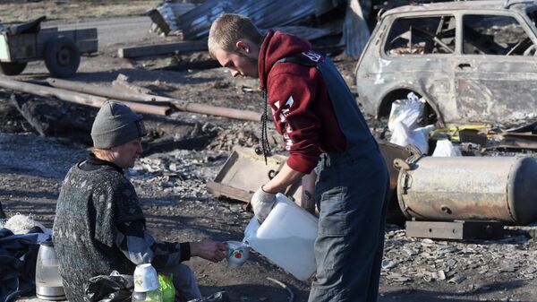 Люди у своего сгоревшего дома в городе Уяре Красноярского края