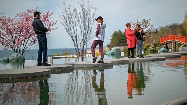 Туристы гуляют в японском саду Шесть чувств на территории санаторно-курортного комплекса Mriya Resort & SPA в Крыму