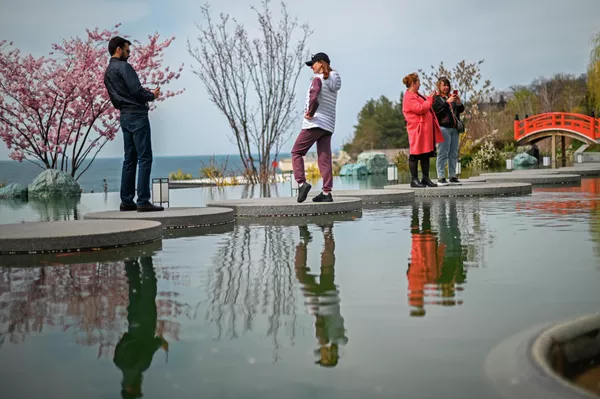 Туристы гуляют в японском саду Шесть чувств на территории санаторно-курортного комплекса Mriya Resort & SPA в Крыму