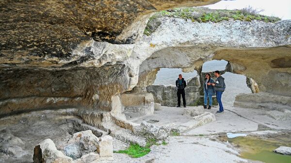 Туристы в пещерах древнего города-крепости Эски-Кермен в Бахчисарайском районе Крыма