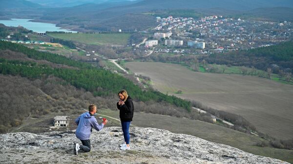 Молодой человек делает предложение своей девушке в районе Партизанского водохранилища на территории базы отдыха ЭкоРест в селе Каштановом в Крыму
