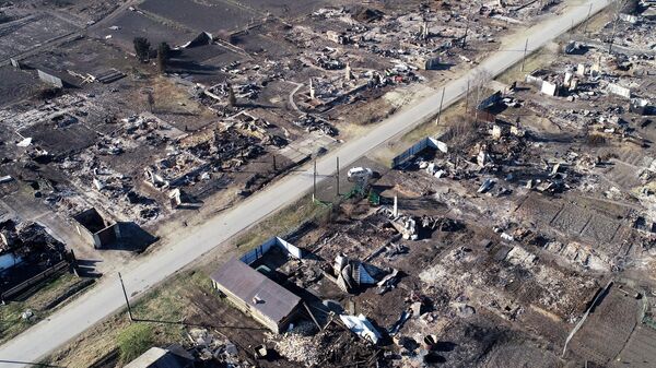 Вид на сгоревшие дома и автомобили в деревне Лакино Большемуртинского района Красноярского края