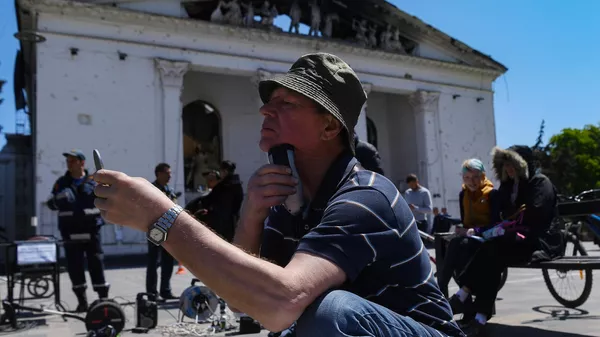Ένας άνδρας ξυρίζεται με ένα ηλεκτρικό ξυράφι συνδεδεμένο με μια γεννήτρια του Υπουργείου Καταστάσεων Έκτακτης Ανάγκης της Ρωσικής Ομοσπονδίας στην Πλατεία Θεάτρου στη Μαριούπολη