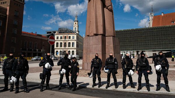 Сотрудники полиции стоят в оцеплении на несанкционированном митинге против сноса памятника советским воинам-освободителям Советской Латвии от немецко-фашистских захватчиков в Риге