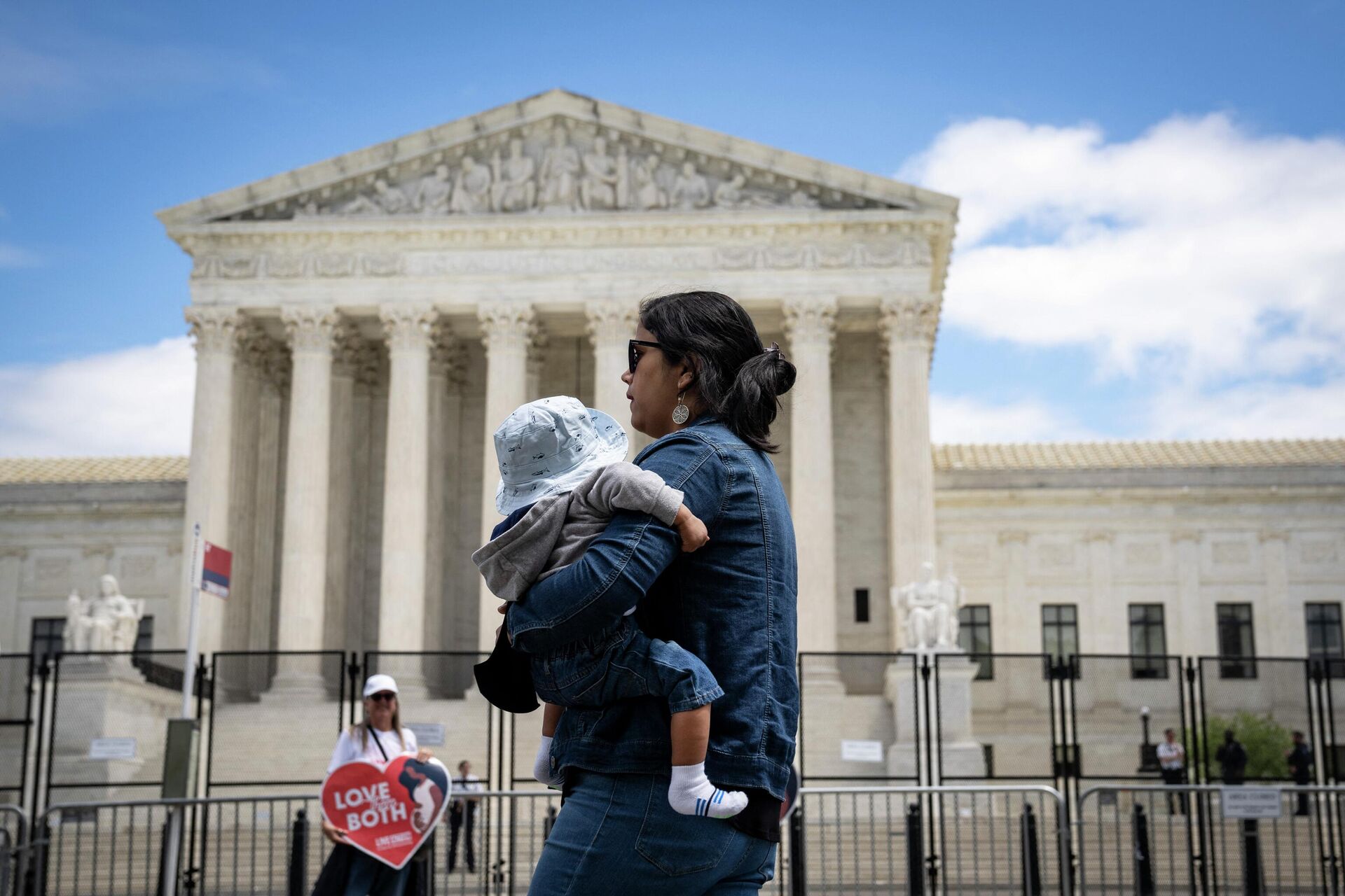 Женщина с ребенком проходит мимо здания Верховного суда США в Вашингтоне - РИА Новости, 1920, 13.05.2022