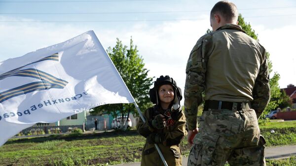 Восьмилетний мальчик Алеша общается с российским военнослужащим в селе Веселая Лопань в Белгородской области