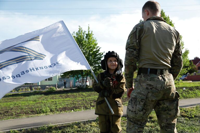 Восьмилетний мальчик Алеша общается с российским военнослужащим в селе Веселая Лопань в Белгородской области