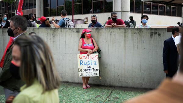 Женщина с плакатом Спасибо, Россия, за денацификацию ЕС и США в Каракасе, Венесуэла