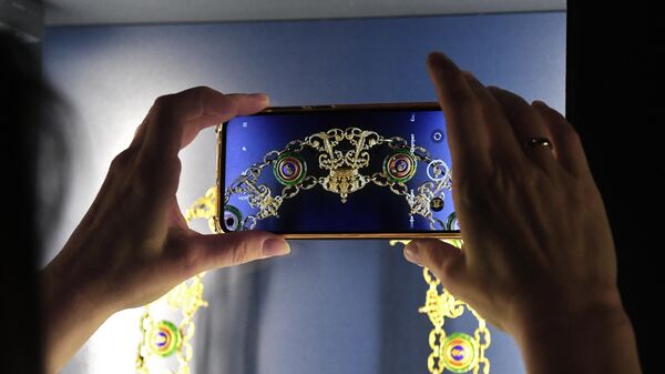 Посетительница фотографирует на выставке Драгоценные ордена из собрания Исторического музея в Москве
