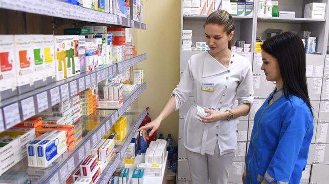 Фармацевты возле полок с лекарствами в аптеке. Архивное фото