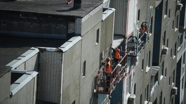 Рабочие проводят ремонт жилого дома