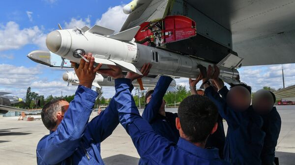 Техники вешают авиационную ракету Р-73 на узел подвески вооружения истребителя ВКС России