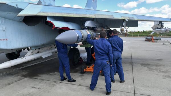 Техники вешают авиационную ракету Х-31 на узел подвески вооружения истребителя ВКС России