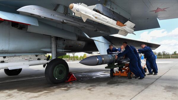 Техники подвозят авиационную ракету, чтобы смонтировать на истребитель ВКС России, задействованный в специальной военной операции на Украине