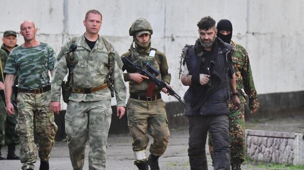 Военные сопровождают одного из сдавшихся в плен украинских военнослужащих с Азовстали