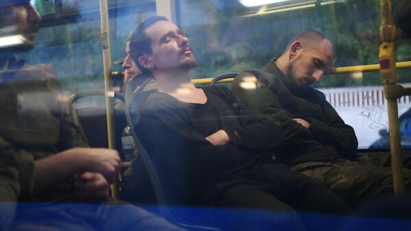 Сдавшиеся в плен украинские военнослужащие и боевики националистического батальона Азов сидят в автобусе у следственного изолятора в Еленовке 