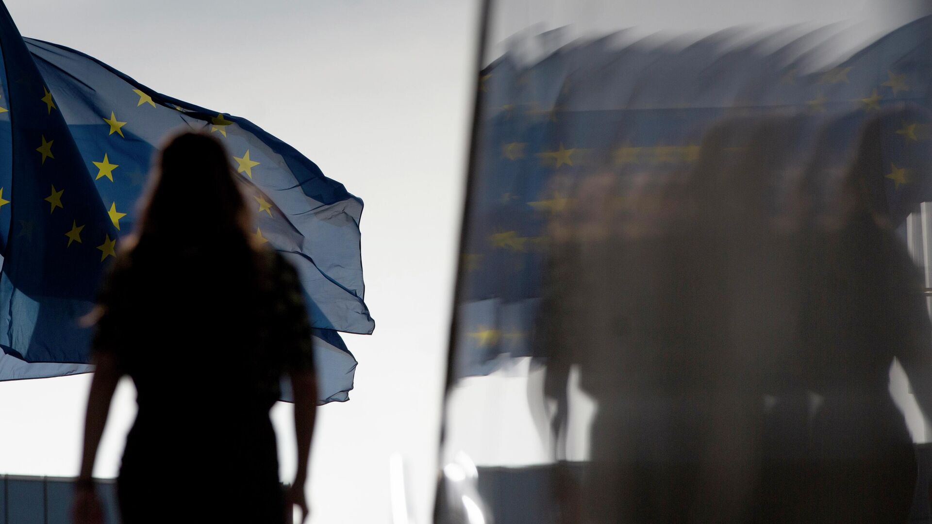 Женщина на фоне флага Евросоюза у штаб-квартиры ЕС в Брюсселе - РИА Новости, 1920, 19.05.2022