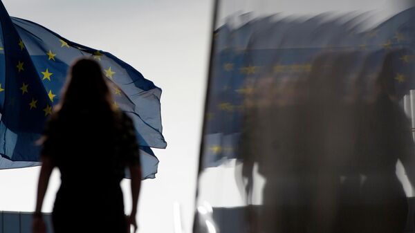 Женщина на фоне флага Евросоюза у штаб-квартиры ЕС в Брюсселе