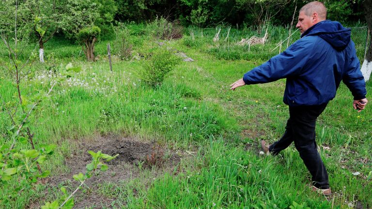 Воронка от снаряда в селе Солохи в Белгородской области, подвергшемся обстрелу со стороны Украины