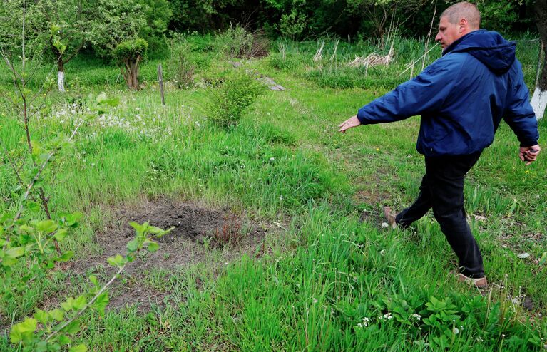 Воронка от снаряда в селе Солохи в Белгородской области, подвергшемся обстрелу со стороны Украины