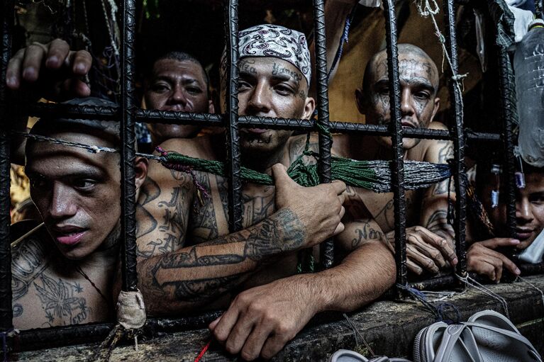 Снимок Inmates look out of a cell из серии Sin Salida фотографа из Великобритании Tariq Zaidi , получивший награду Merit Award на конкурсе All About Photo Awards 2022