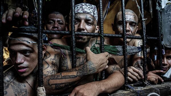 Снимок Inmates look out of a cell из серии Sin Salida фотографа из Великобритании Tariq Zaidi , получивший награду Merit Award на конкурсе All About Photo Awards 2022