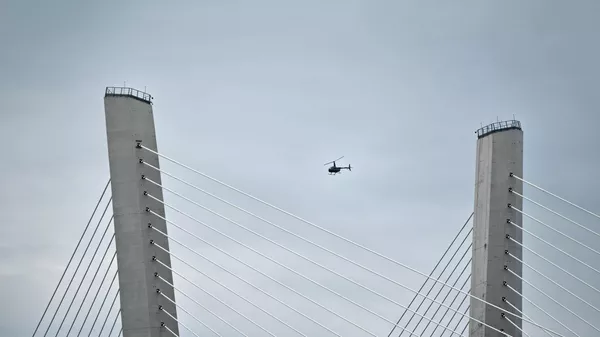 Вертолет пролетает мимо Золотого моста во Владивостоке