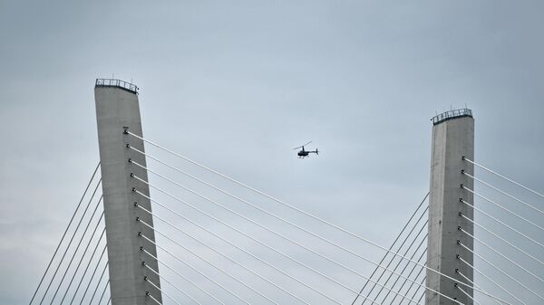Вертолет пролетает мимо Золотого моста во Владивостоке Вертолет пролетает мимо Золотого моста во Владивостоке